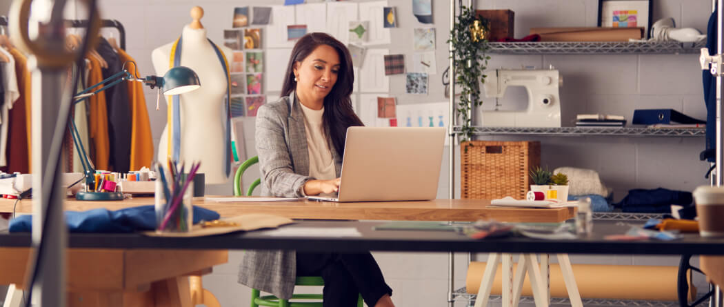 Business woman seated in a studio using a laptop