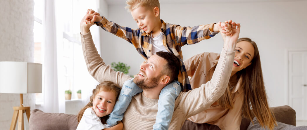 young family playing on a couch