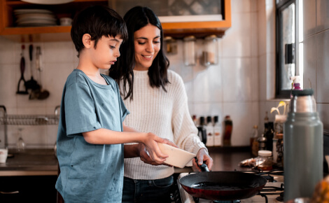 Young mom cooking with boy