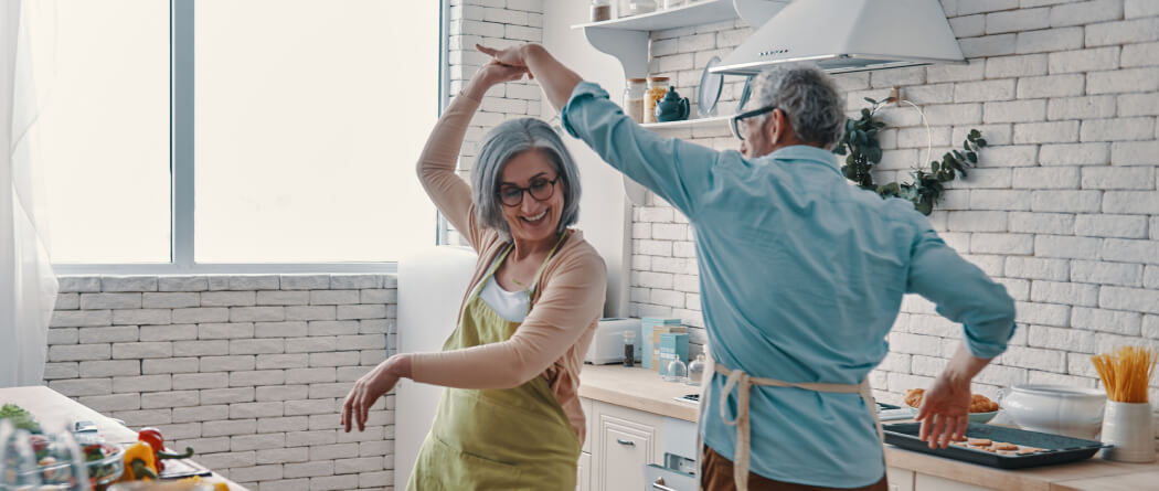 Mature couple dancing in white kitchen